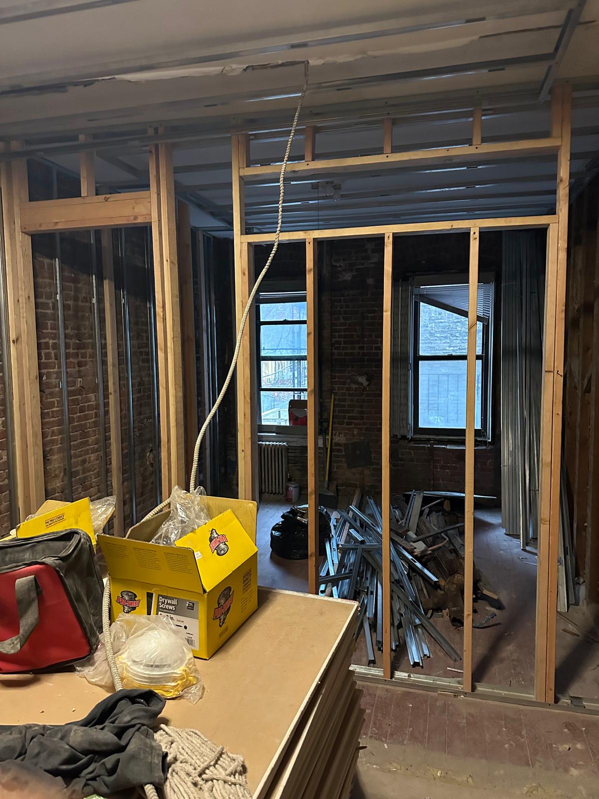 Before: new stud framing against exposed brick